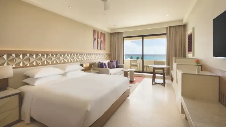 Club Oceanfront King room with king bed, sitting area, and private balcony overlooking the Caribbean Sea at Hyatt Ziva Cancun.